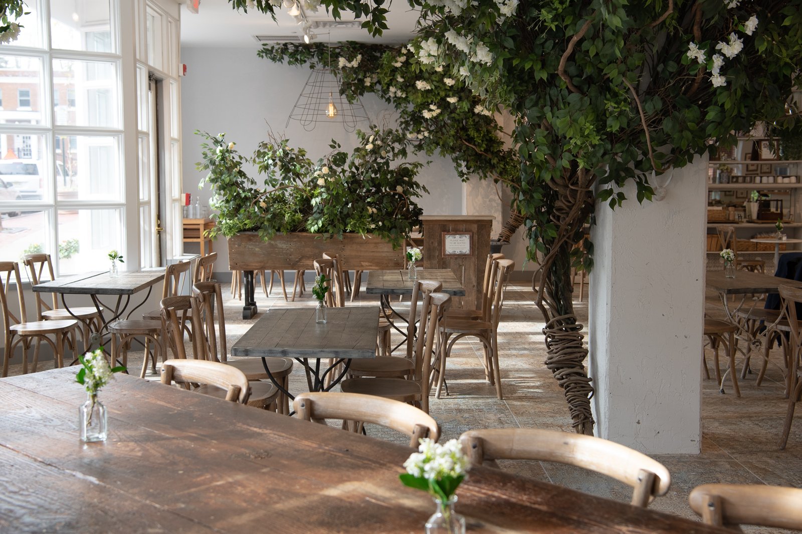 Floral greenery and warm wood tables at Maman Princeton